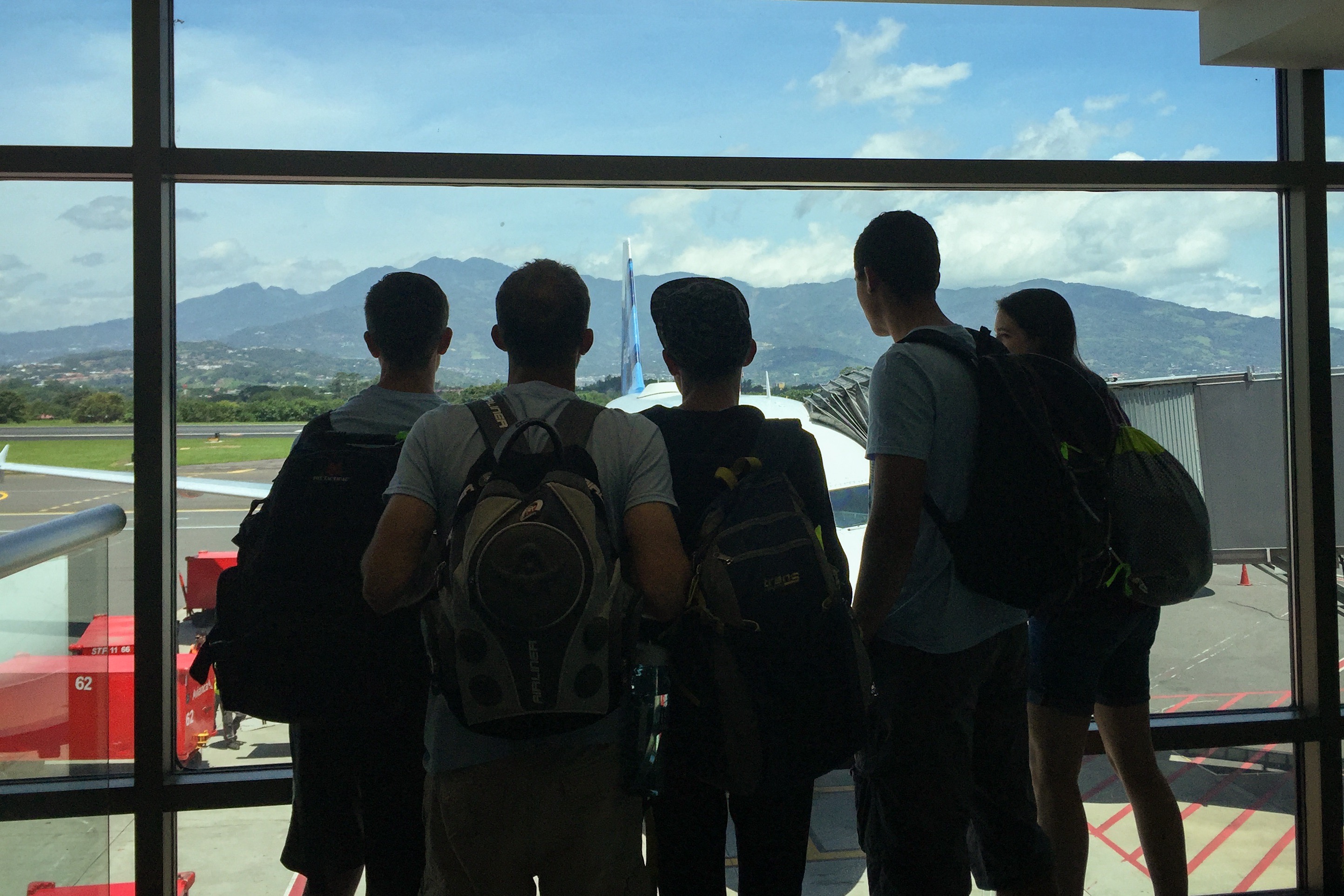 people at an airport looking out onto the tarmac
