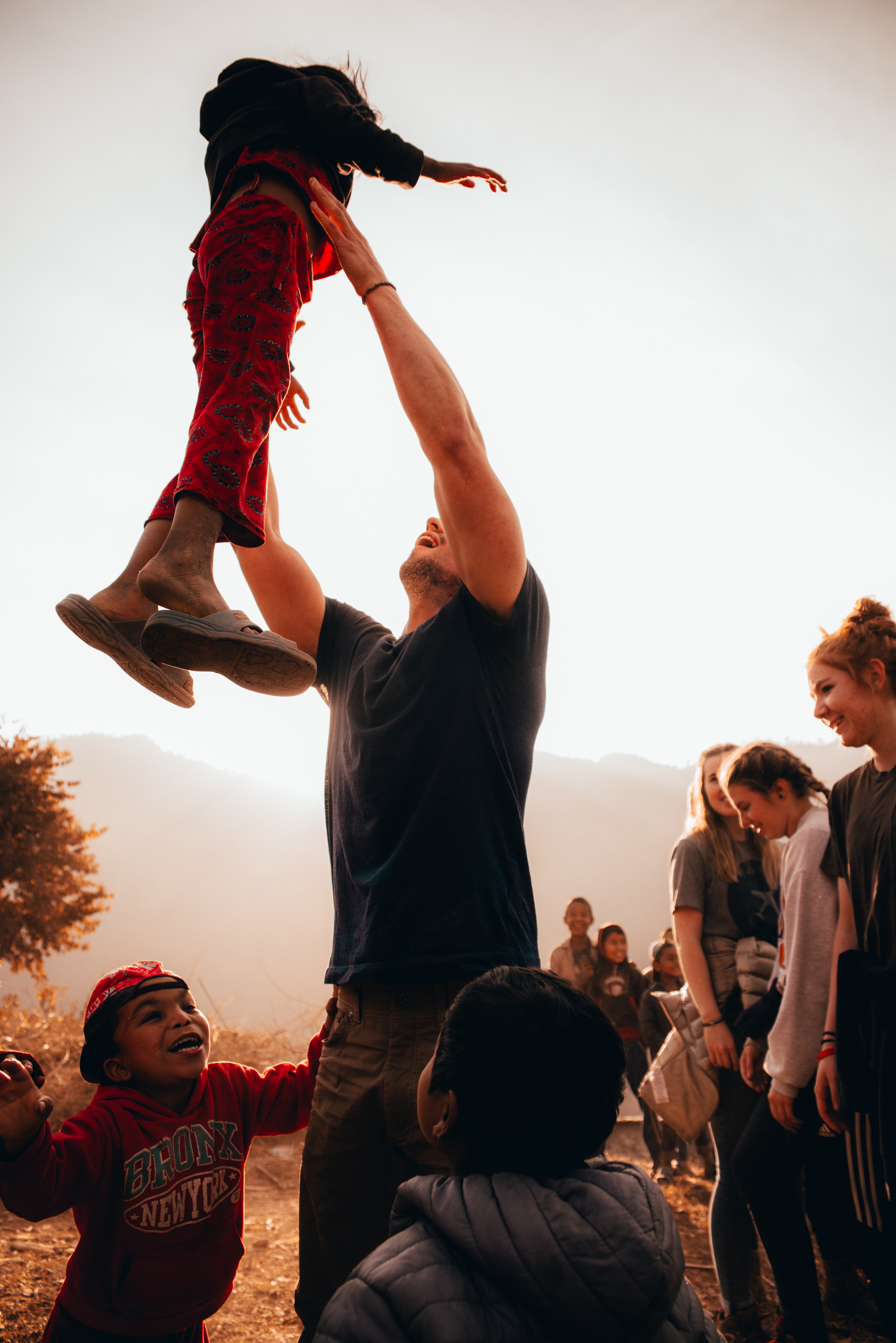 man throwing boy in the air playing