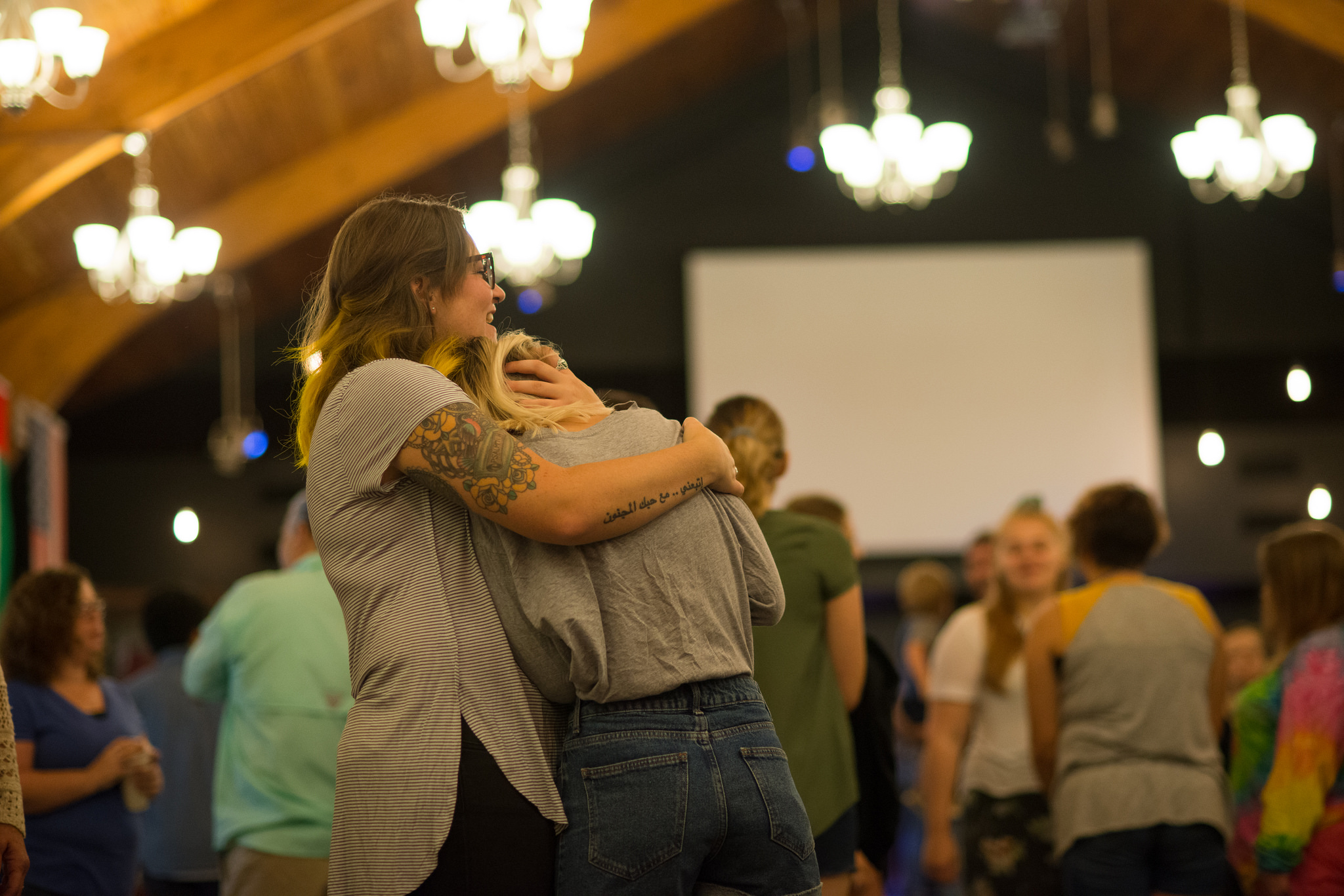 two women hugging in the chapel at youth with a mission