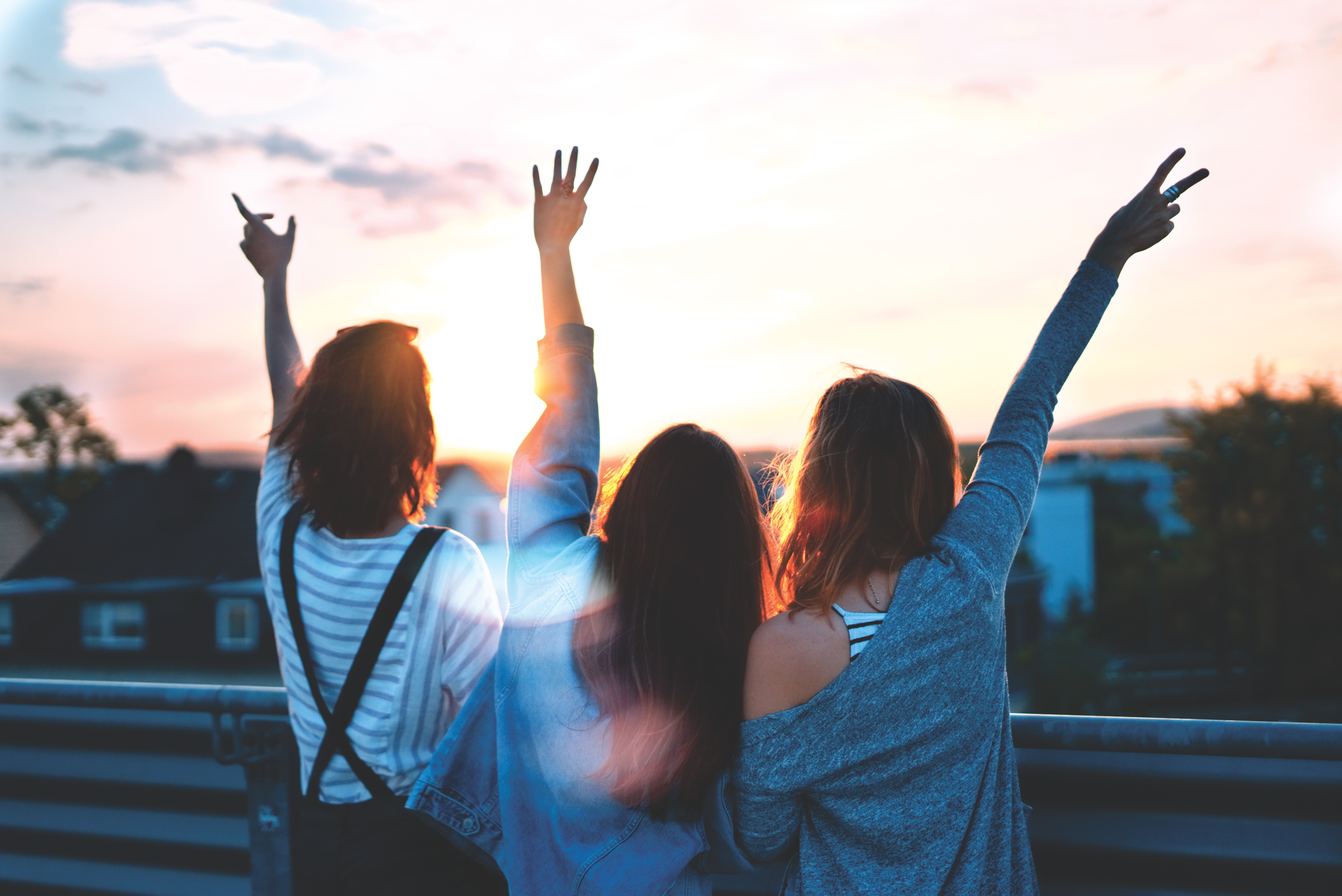 Women-waving-hands Three women friends waving hands watching sunset