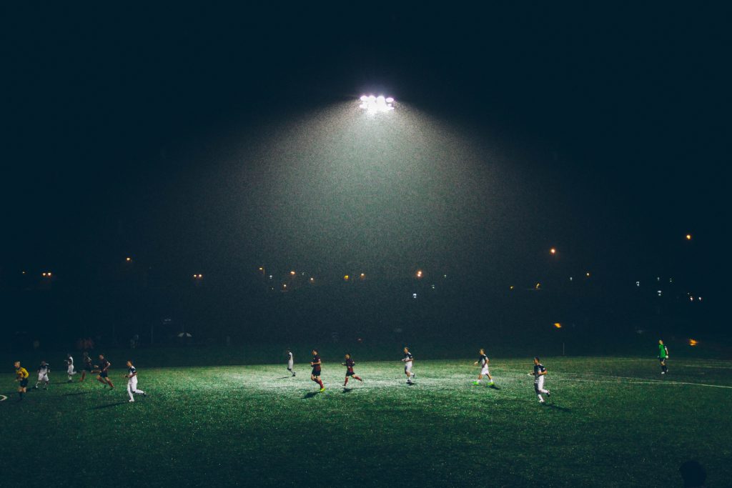players on soccer field under light
